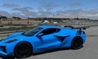 Blue 2025 Chevrolet Corvette C8 shown from front three-quarter angle on a racetrack.
