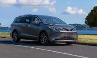 Gray 2025 Toyota Sienna Platinum parked near the waterfront in a front three-quarter view.