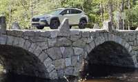 2026 Subaru Crosstrek Hybrid crosses a stone arch bridge in Central New Hampshire