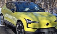 A Volvo EX30 looks sporty in yellow against a winter backdrop