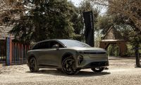 Lucid Gravity SUV parked outdoors at event with trees and buildings