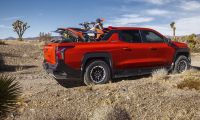 Red 2026 Chevy Silverado EV Trail Boss with motorcycles in bed