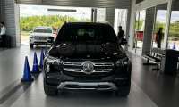 Ry's Mercedes-Benz GLE 350 is parked in a showroom with a gray tiled floor. Blue cones are placed in front. A white SUV is visible in the background.