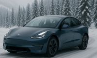 Tesla Model 3 driving on a cold, snow-covered mountain road