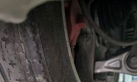 Picture of rear tire on a Tesla with excessive wear on the inside due to poor camber adjustment