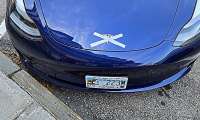 A Tesla Model Y is shown with tape crossing out its logo in a protest of Elon Musk's political opinions. 