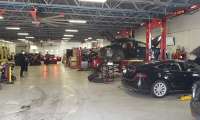 A Tesla service center shows many vehicles waiting for service