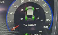 An in-dash vehicle tire pressure display shows that tires are overinflated.