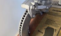 An automotive brake display explains how the rotor, caliper and brake pads work