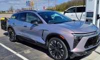 Front three-quarter view of Christopher’s Chevy Blazer EV connected to a fast charger during a road trip stop.