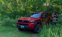 Ethan Hanna's red 2026 Toyota 4Runner parked on a wooded trail while towing a small trailer, before its transmission was replaced at approximately 6,500 miles following concerns about harsh shifting.