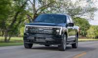 Ford F-150 Lightning Platinum electric pickup truck driving on a public road.