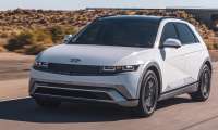Silver Hyundai Ioniq 5 Limited electric SUV driving on a desert highway near an overpass, front three-quarter view