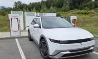 A 2026 Hyundai Ioniq 5 Limited charges at a Tesla Supercharger occupying two spaces