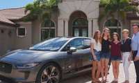 A family stands next to a Jaguar
