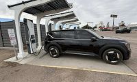 Black Kia EV6 electric vehicle charging at solar-powered charging station