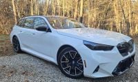 2025 BMW M5 Touring wagon set against a forest backdrop