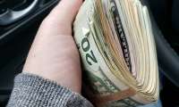 A car shopper holds a bunch of money