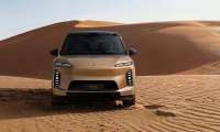 Gold Nio ES9 SUV shown from the front on desert sand dunes.