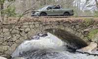 2026 Honda Ridgeline shown crossing a stone arch bridge