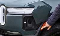 An EV drive points to the charge port of a Rivian R1S