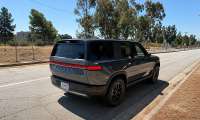 Gray Rivian R2 shown from the rear three-quarter angle on a city street.