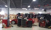 Tesla service areas shows a Tesla Model behind a large stack of tires