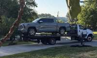 Tiffany’s 2024 Toyota Tundra being loaded onto a flatbed tow truck after experiencing an engine failure at 30,000 miles.