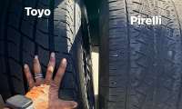 Close-up comparison of Toyo and Pirelli tire tread wear with labels on each tire.
