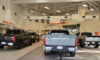 Toyota Tundras line up to enter a Toyota dealer service area