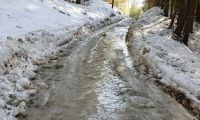 A rural road is shown covered in a foot of ice
