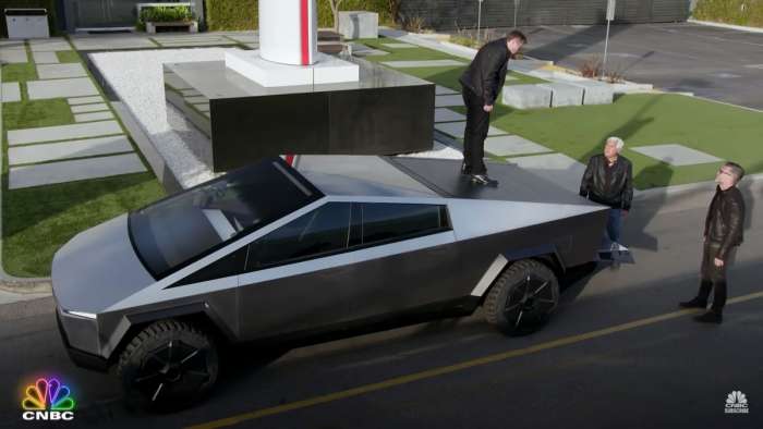 Image showing Elon Musk standing on the bed cover of the Tesla Cybertruck as he shows it to Jay Leno.