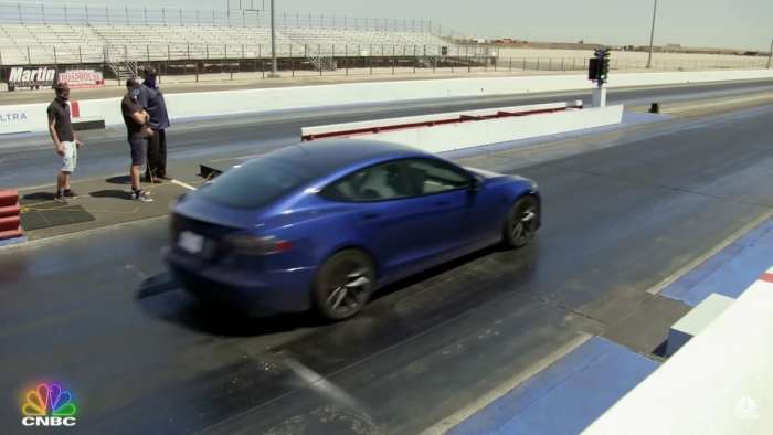 Image showing Jay Leno racing a dark blue Tesla Model S Plaid at a drag strip.